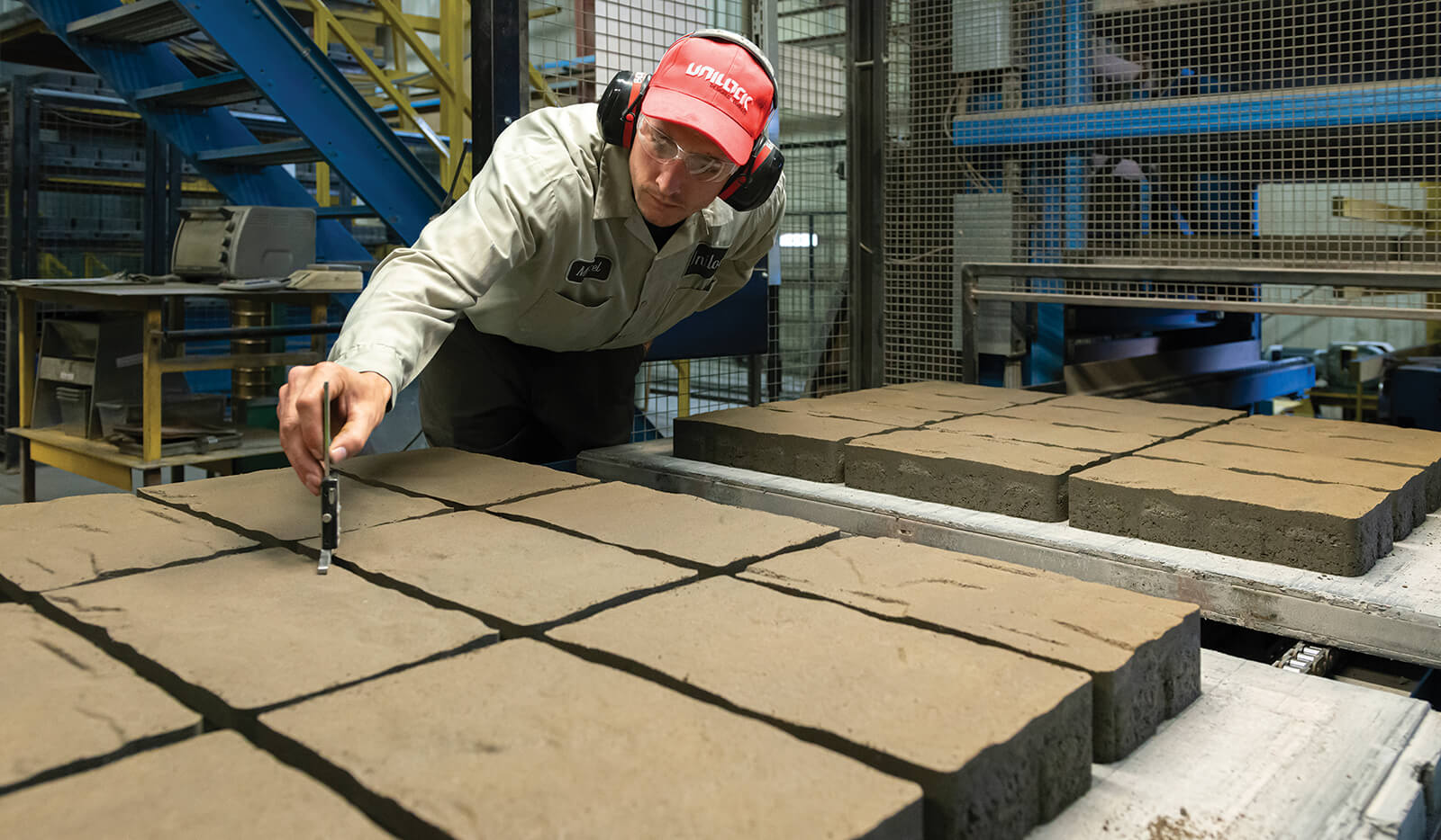 man checking paver quality at a manufacturing plant