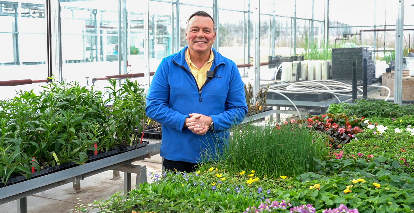 man in a greenhouse with plants